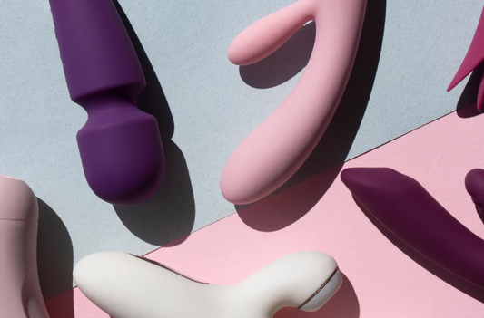 Assorted vibrators on pink and blue geometric surfaces.