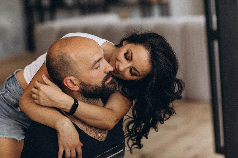 Couple embracing indoors.