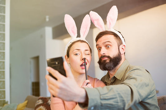 Couple wearing bunny ears taking a selfie.
