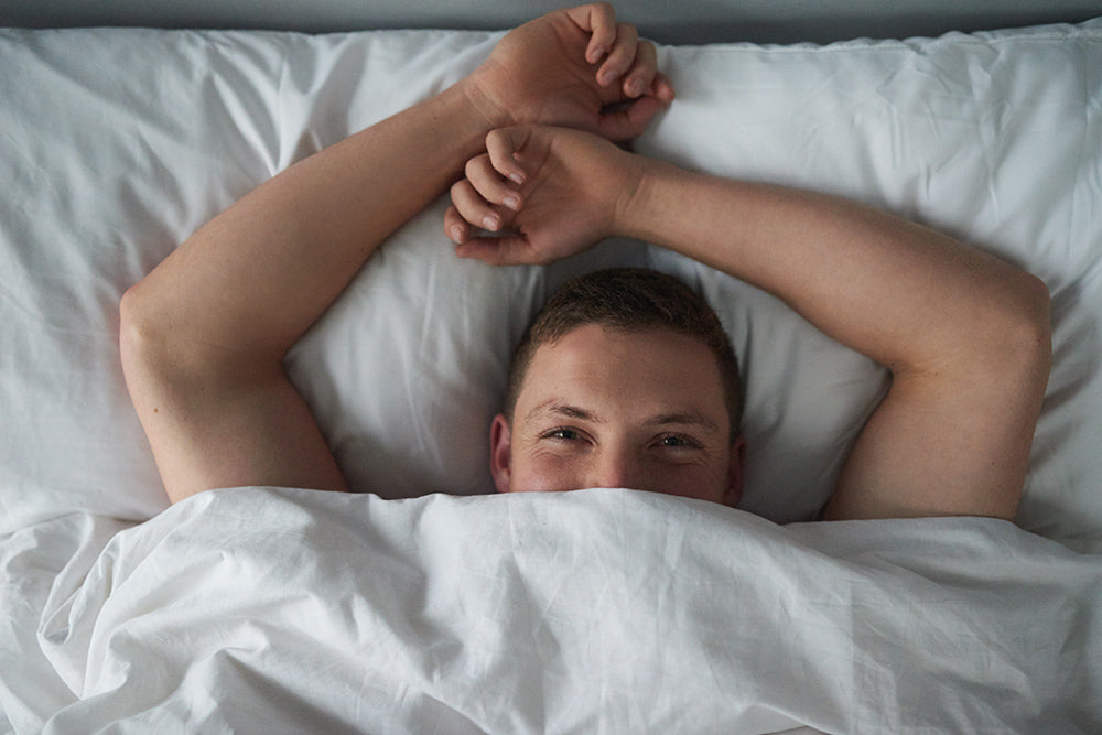 Man smiling while lying in bed.