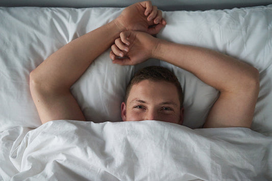 Man smiling while lying in bed.