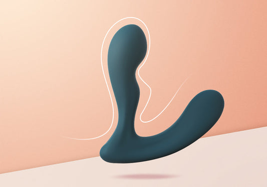 Dark green prostate massager on a peach background.