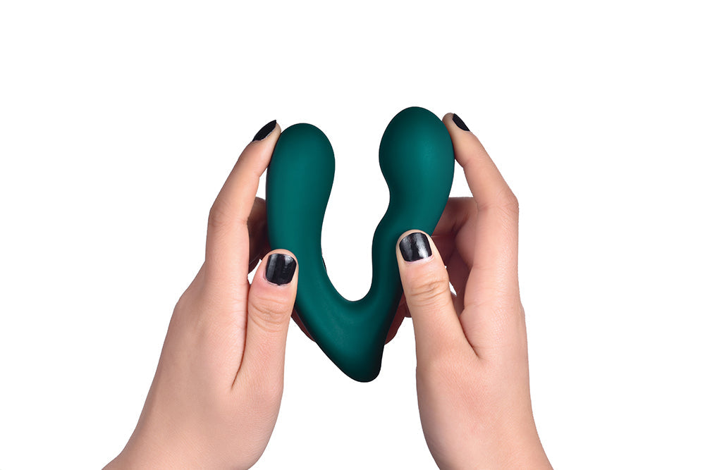 Hands holding a green dual-ended vibrator.