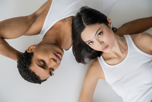 Couple lying side by side in white tops.
