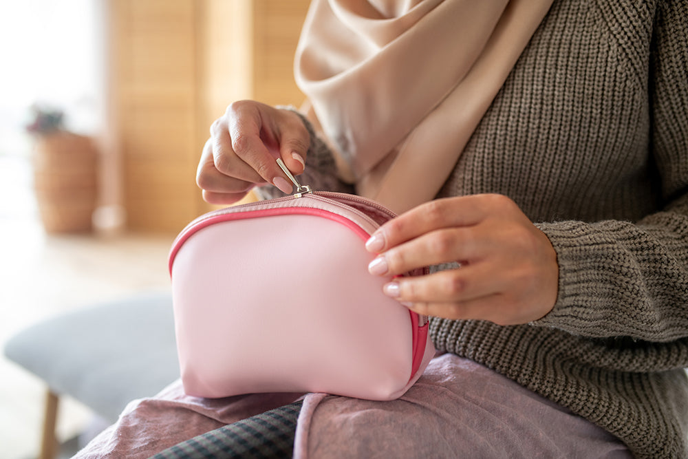 Person opening a pink travel case.