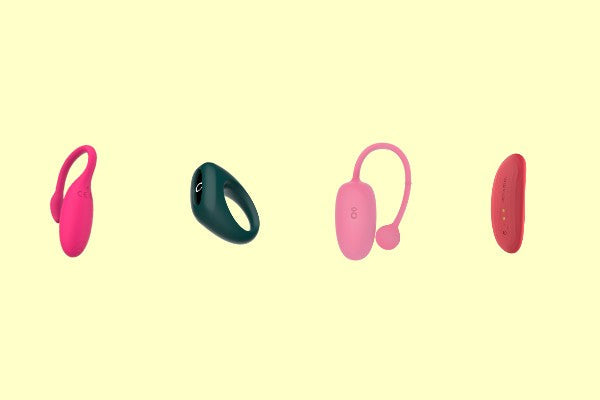 Four pink and green wearable vibrators on a pale yellow background.
