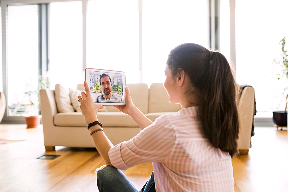 Woman holding a tablet during a video call.
