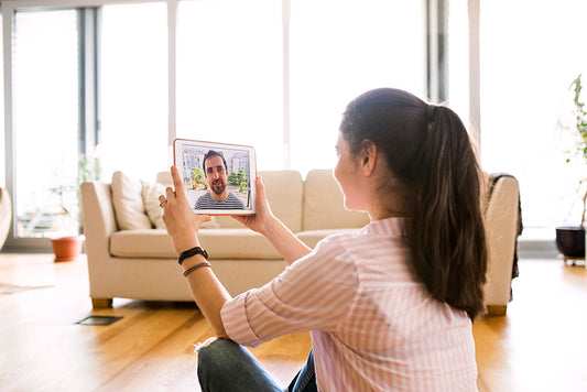 Woman holding a tablet during a video call.