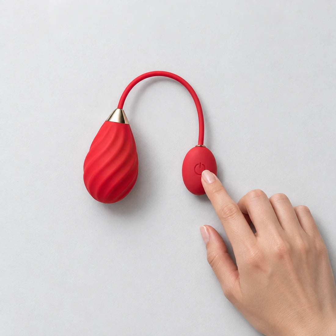 Hand touching the button on a red Magic Sundae resting on a table